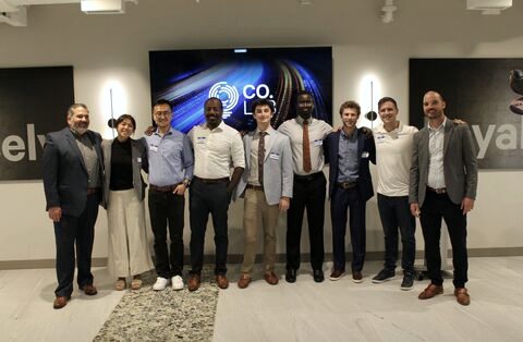 Nine people standing in a row in front of a screen with the CO.LAB logo. Sankung Fatty is fifth from the left, in a white shirt.